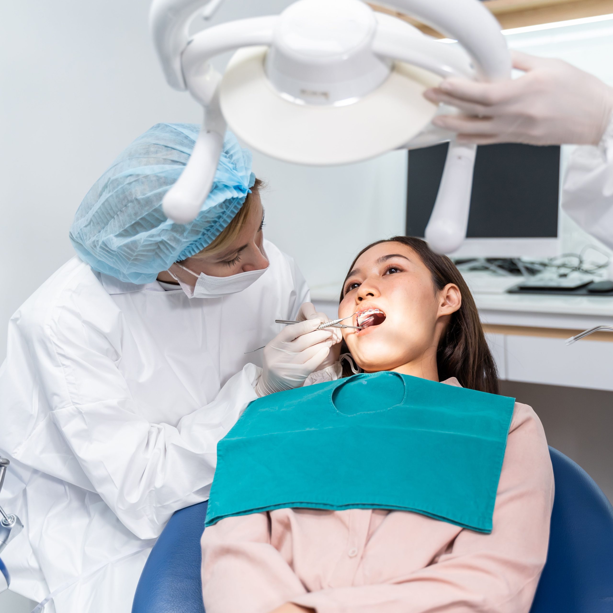 Young female dentist in dental office. Dentist at work. Dental treatment concept.